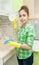 Girl Gloved washes cupboards, stove and sink in the kitchen