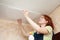 Girl glues ceiling tile