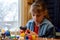 A girl glues a decorative element to crafts with a glue gun