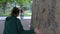 The girl goes around the ancient large oak tree in the center of the Yalta embankment. Crimea