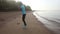 girl goes at jog trot along beach at sunrise
