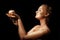 Girl with golden bodyart posing with golden apple