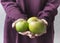 Girl golding three apples in her hands