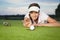 Girl golfer making a trick on green.