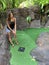 Girl golfing at a miniature golf place in summertime.