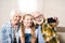 Girl with grandmother and grandfather sitting on sofa and taking selfie