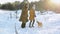 Girl and grandmother walking with a dog in a snowy winter park on a background of snow covered trees, sunny frosty day.