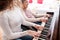 A girl with grandmother in wheelchair playing the piano.