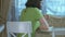 Girl in a green dress sitting at the table eats