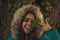 Girl with green jacket in the forest discovering its wonders, its vegetation, its trees and leaves