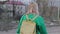 A girl in a green sweater with a backpack behind him is an abandoned wasteland in the city. The camera moves behind her.