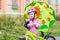 Girl with a green umbrella stands with her Bicycle