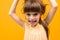 Girl grimaces and twists her hair on a yellow background