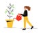 The girl grows a coin tree. A woman waters a money tree. A girl with a watering can in her hands.