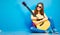 Girl with guitar against blue . hipster style portrait