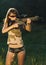 Girl with a gun for trap shooting and shooting glasses aiming at