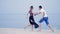 Girl and the guy running on the sand near the sea - love playing fun games