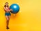 Girl with gym ball and headset is ready to start fitness activity