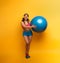 Girl with gym ball and headset is ready to start fitness activity