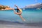 Girl Gymnast, jump, Sardinia, Porto Istana beach facing the island of Tavolara.