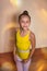 Girl gymnast in a yellow swimming suit. The concept of sports, dance