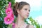 Girl with hairstyle and pink hollyhocks