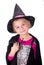 a girl in a halloween costume holds a black toy spider in her hands on a white background