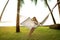 Girl in a hammock bother palm trees enjoying a tropical vacation