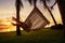 Girl in a hammock bother palm trees enjoying a tropical vacation