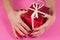 Girl hand hug red gift boxes isolated on pink background
