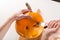 Girl hand make jack o lanterns for Halloween holiday with kitchen knife