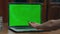 Girl hand pressing key on greenscreen laptop starting video lesson closeup.
