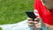 Girl hand texting on phone on the grass