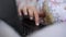 Girl hand with white manicure scrolls laptop display closeup