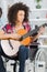 Girl handicapped guitarist sitting on wheelchair