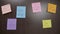 Girl hands adding to handwritten sticky post it notes to her collection of post it with inspirational quotes on her wooden table -