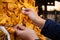 Girl hands adjusting up a good luck yellow paper knot on asian temple