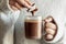 Girl hands dipping cookie in hot chocolate