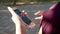 The girl in the hands holding a smartphone that uses social networks. Fingers women touch the touchscreen of the