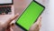 Girl hands swiping green screen telephone looking phone number in office closeup