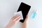 Girl hands wipes black tablet with a disinfectant wipe. White background