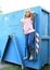 Girl hanging on blue container