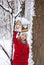 Girl hangs bird feeder in winter snowy forest