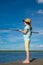 Girl in a hat, against the blue sky with clouds, fishing, standing on the pier