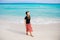 Girl in a hat on a background of the ocean. Beautiful girl looks at the sea