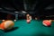 A girl in a hat in a billiard club with a cue in her hands hits a ball.Playing pool