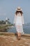 Girl in a hat looking at the ocean