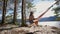 Girl in a hat is resting in an orange hammock.