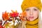 Girl in hat and scarf holding autumn bouquet