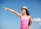 Girl in hat showing direction on the beach